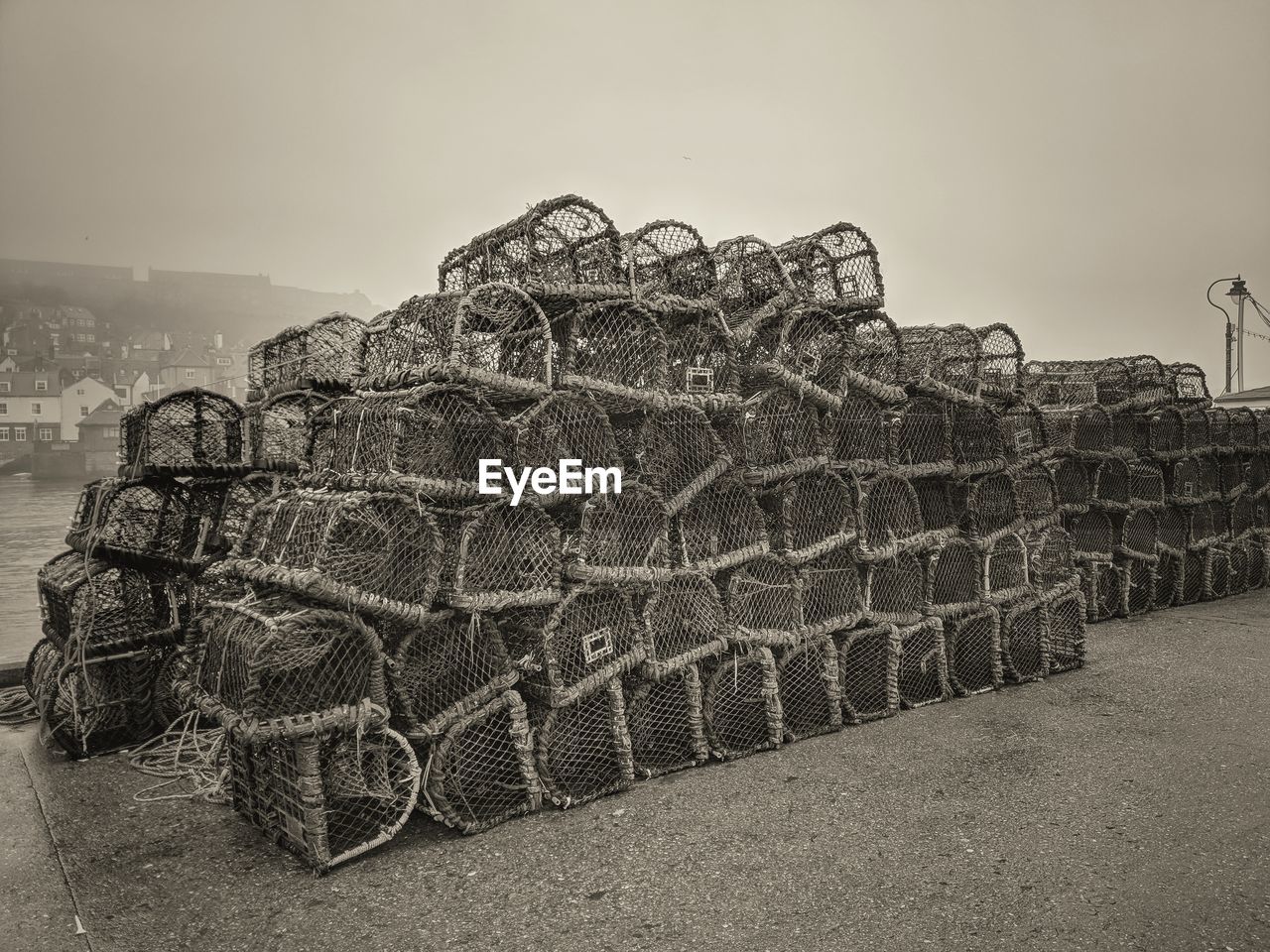 CLOSE-UP OF FISHING NET ON FIELD AGAINST SKY