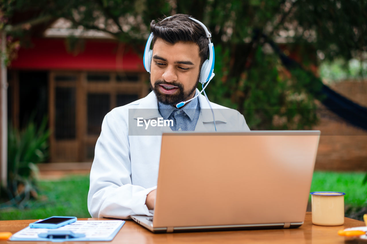 young man using laptop while sitting at office