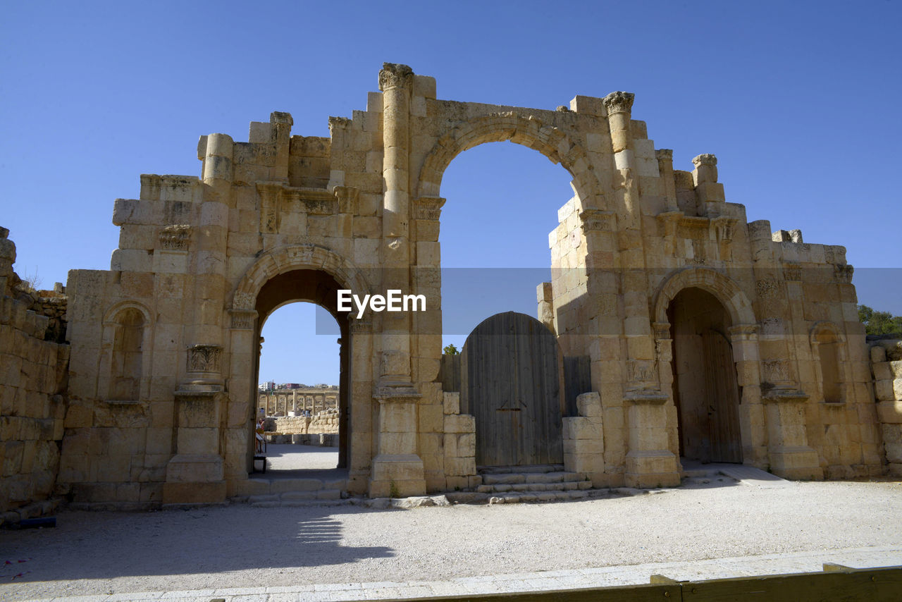 architecture, arch, history, the past, travel destinations, ruins, landmark, ancient, ancient history, historic site, old ruin, travel, nature, built structure, building, sky, monument, tourism, city, clear sky, old, temple, blue, memorial, no people, rock, outdoors, day, sunny
