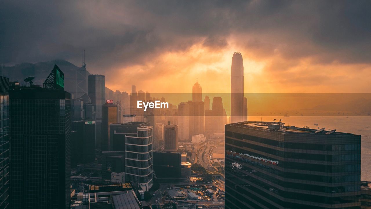 Skyscrapers in city against cloudy sky