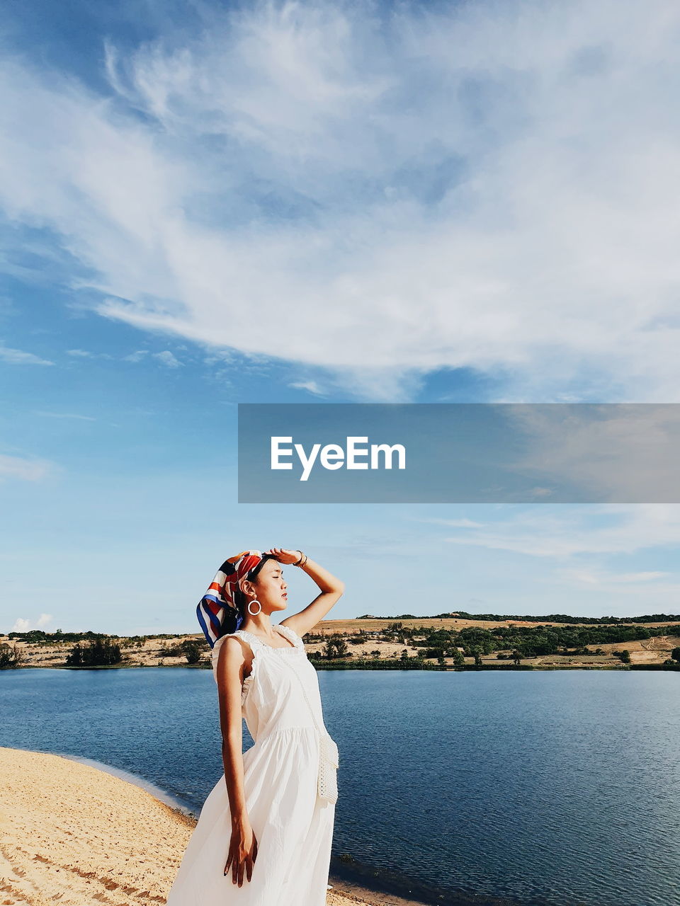 Woman standing by sea against sky