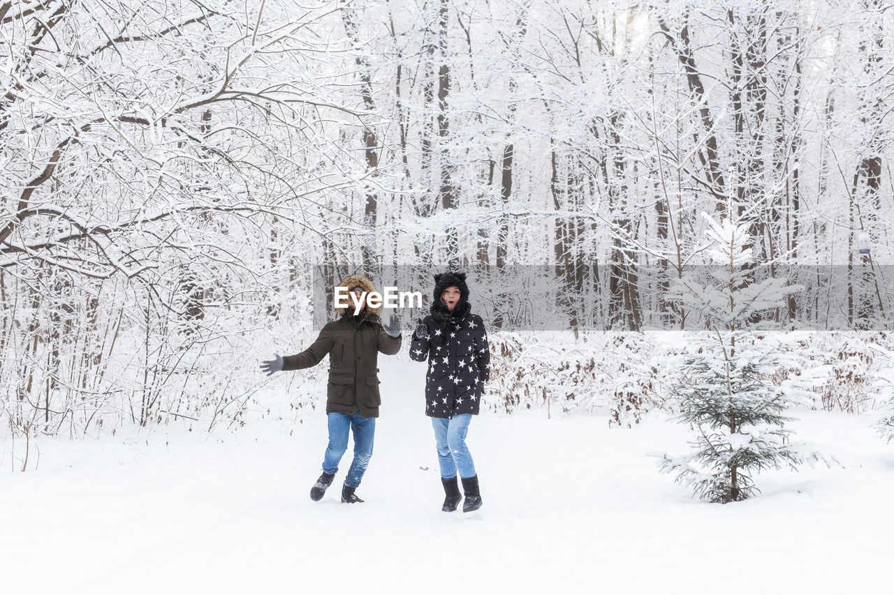 FULL LENGTH OF A YOUNG WOMAN ON SNOW COVERED LAND