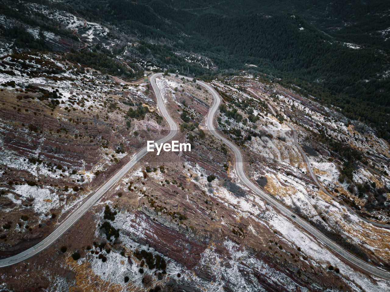 High angle view of mountain road against land and forest
