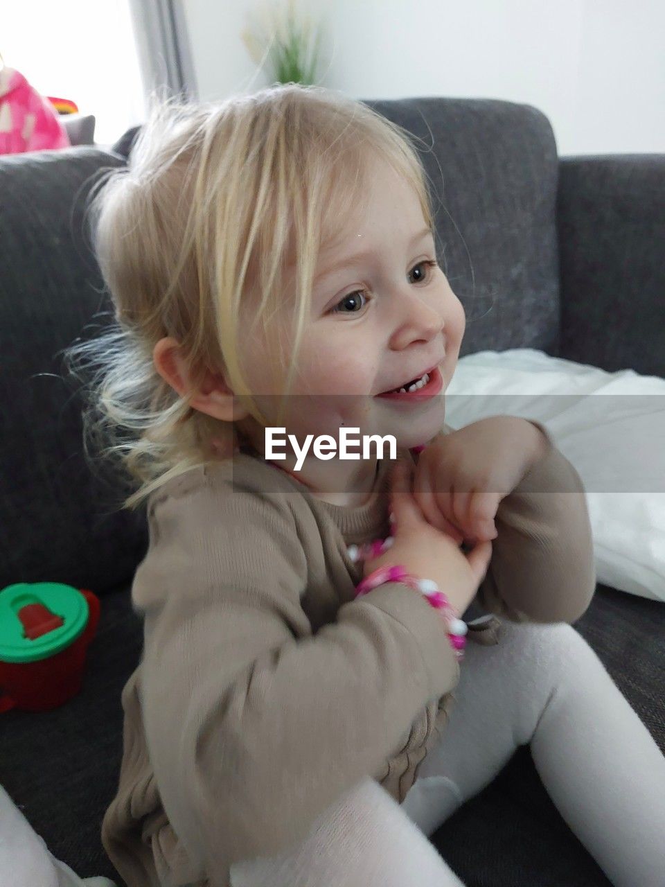 close-up of cute baby boy sitting on sofa at home