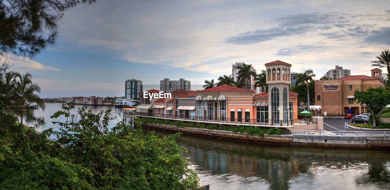 BUILDINGS BY RIVER AGAINST SKY