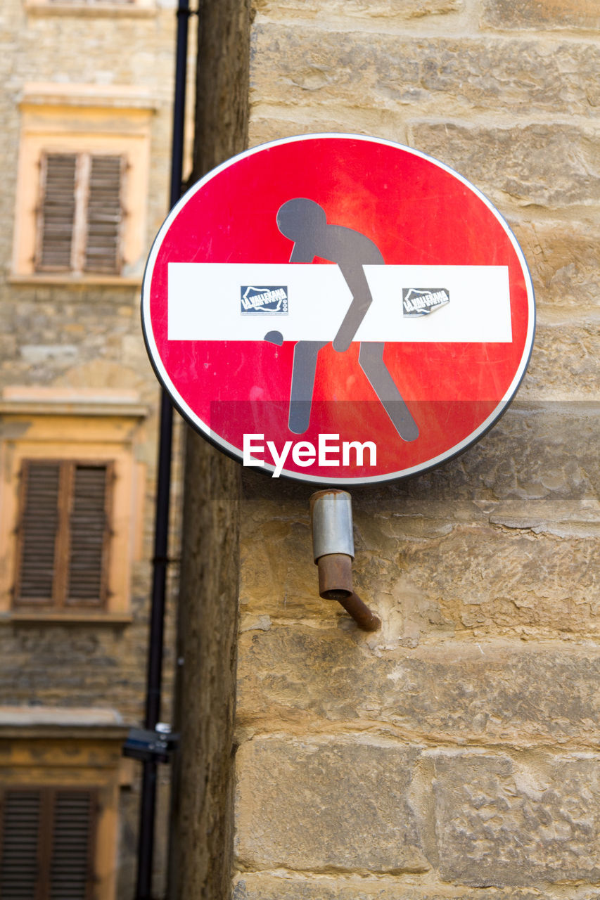 CLOSE-UP OF ROAD SIGN AGAINST BUILDING