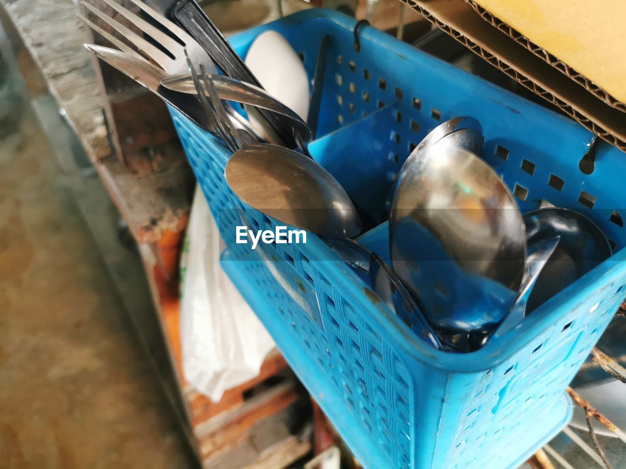 HIGH ANGLE VIEW OF BLUE CONTAINER ON METAL IN KITCHEN