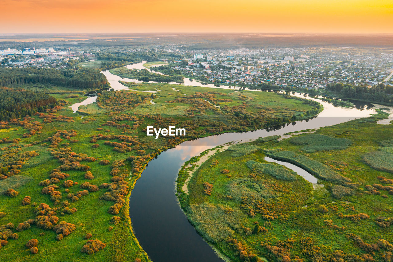 HIGH ANGLE VIEW OF RIVER AMIDST FIELD AND SKY