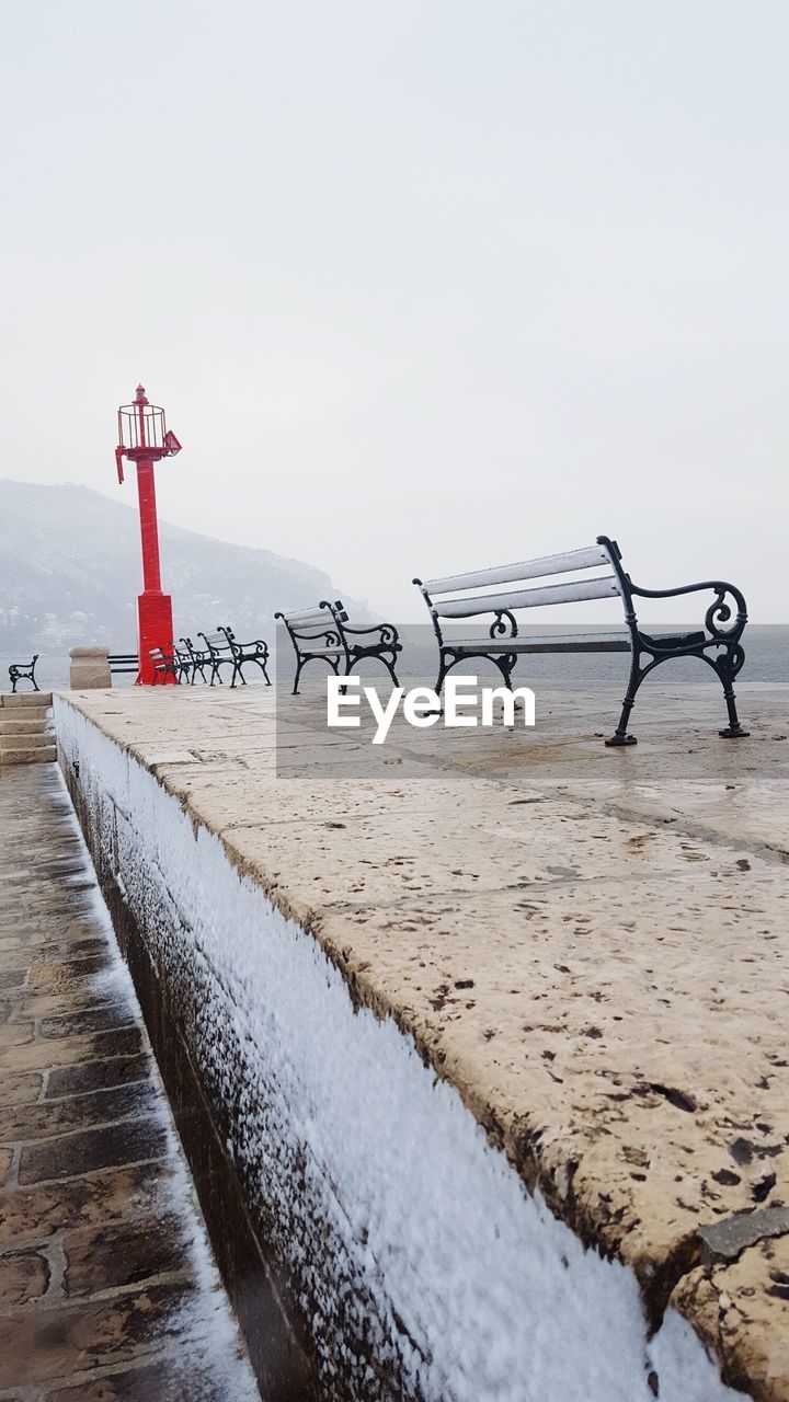 Empty benches by sea