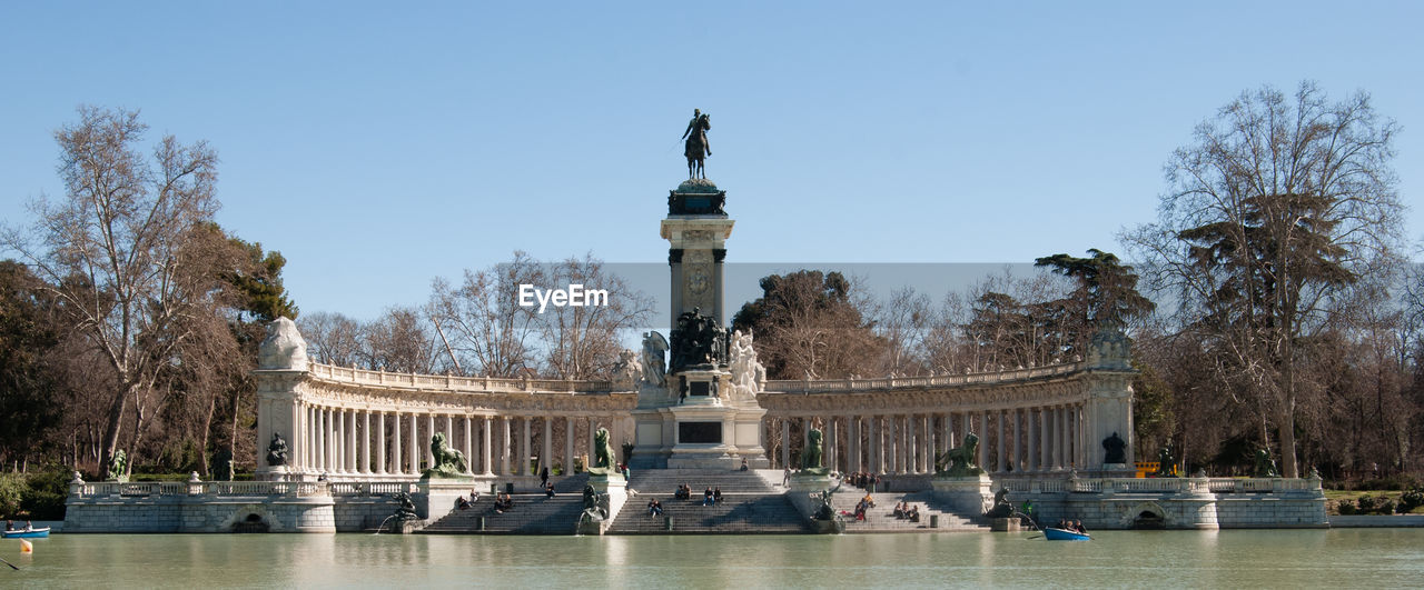 Low angle view of column at buen retiro park against clear sky during sunny day