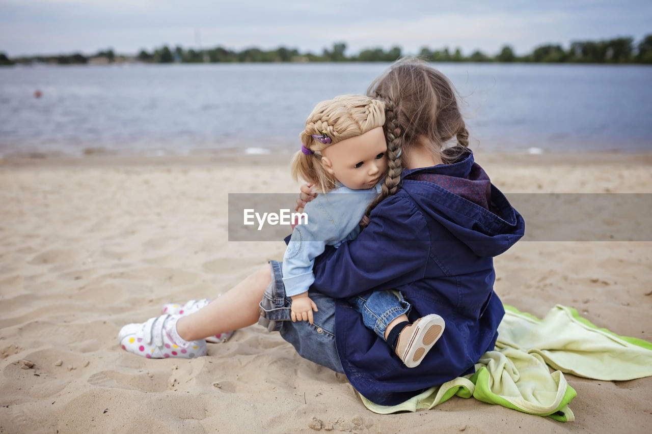 Boy sitting on sand at beach