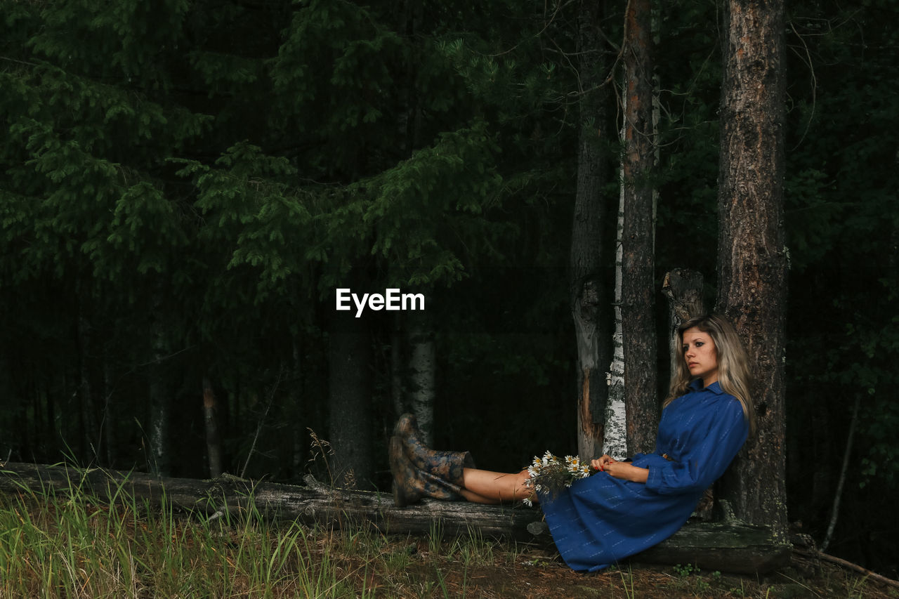 Girl in a blue dress on the background of the forest