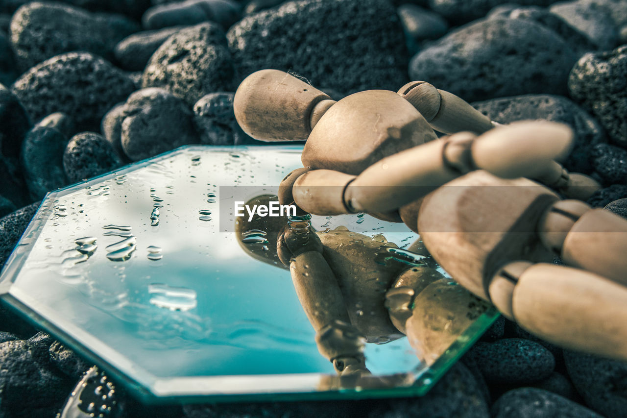 CLOSE-UP OF HAND HOLDING ROCKS