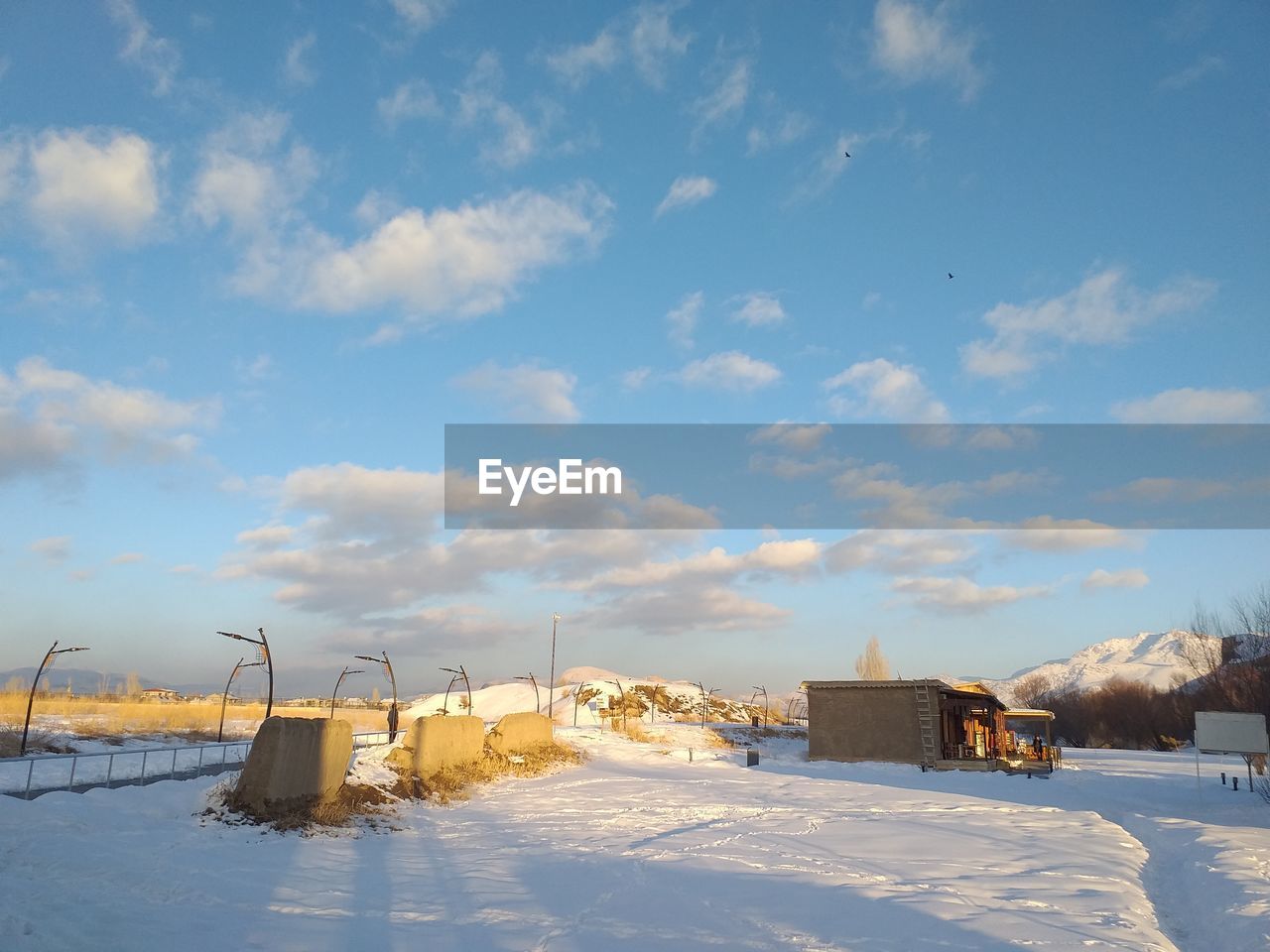 Buildings on snow covered field against sky