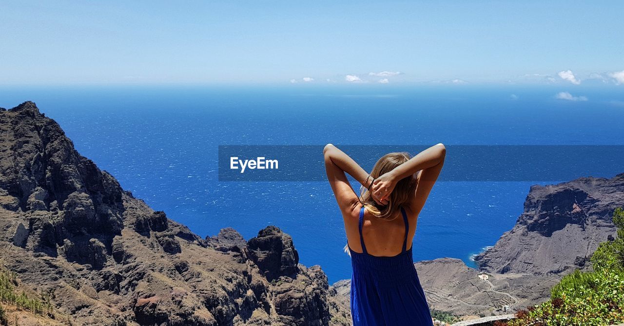 Rear view of woman standing against sea