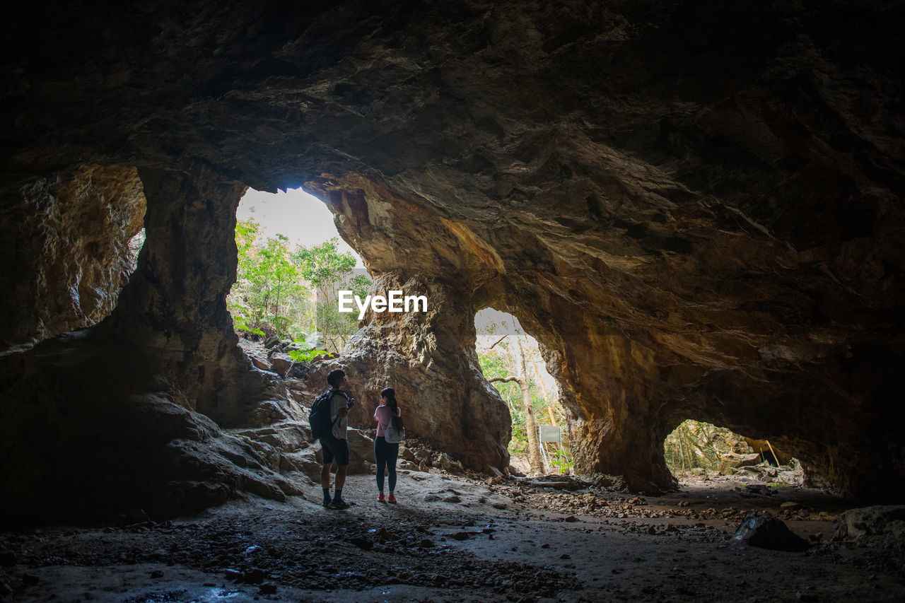 Full length of couple standing in cave