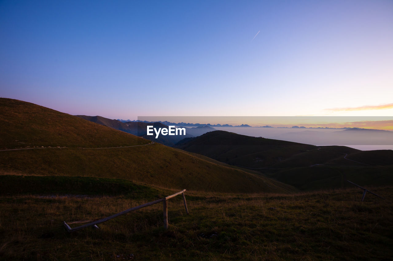 SCENIC VIEW OF LANDSCAPE AGAINST CLEAR SKY DURING SUNSET