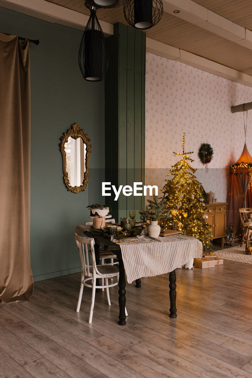 Stylish christmas living room with a festive dining table decorated for christmas eve