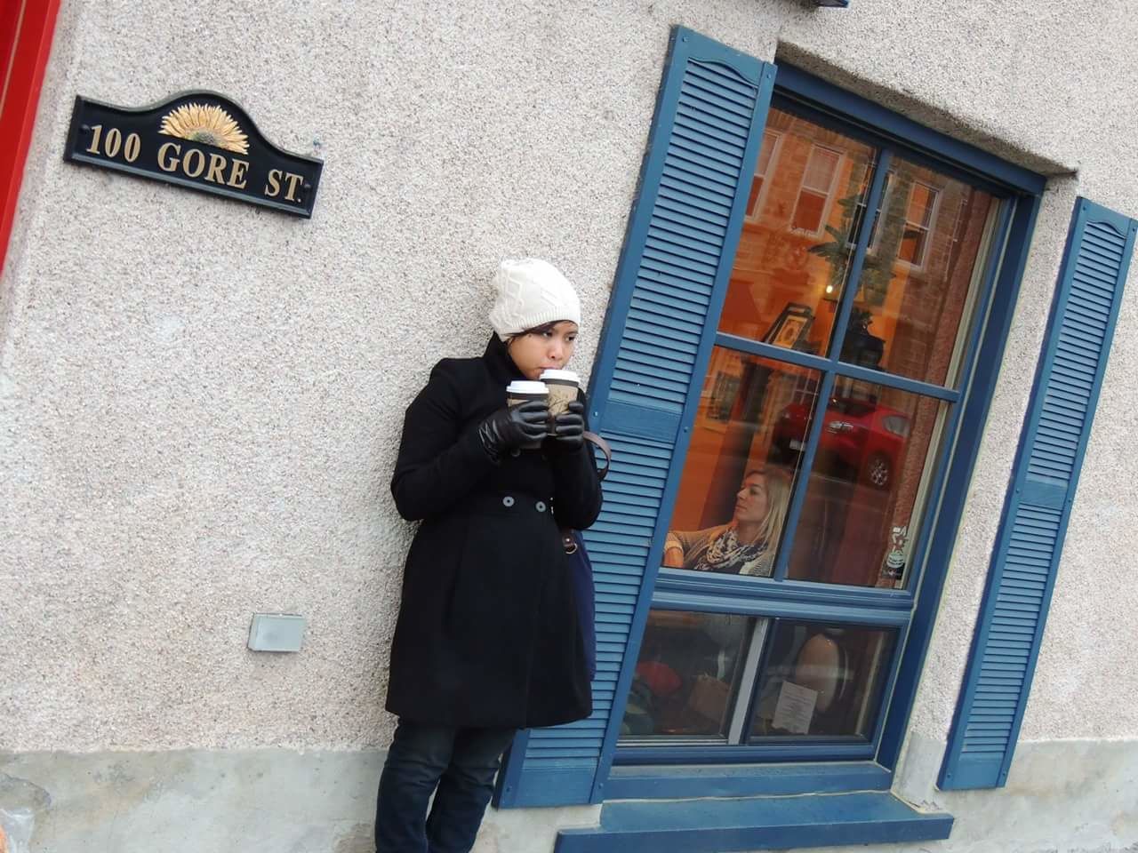 WOMAN STANDING IN FRONT OF BUILDING