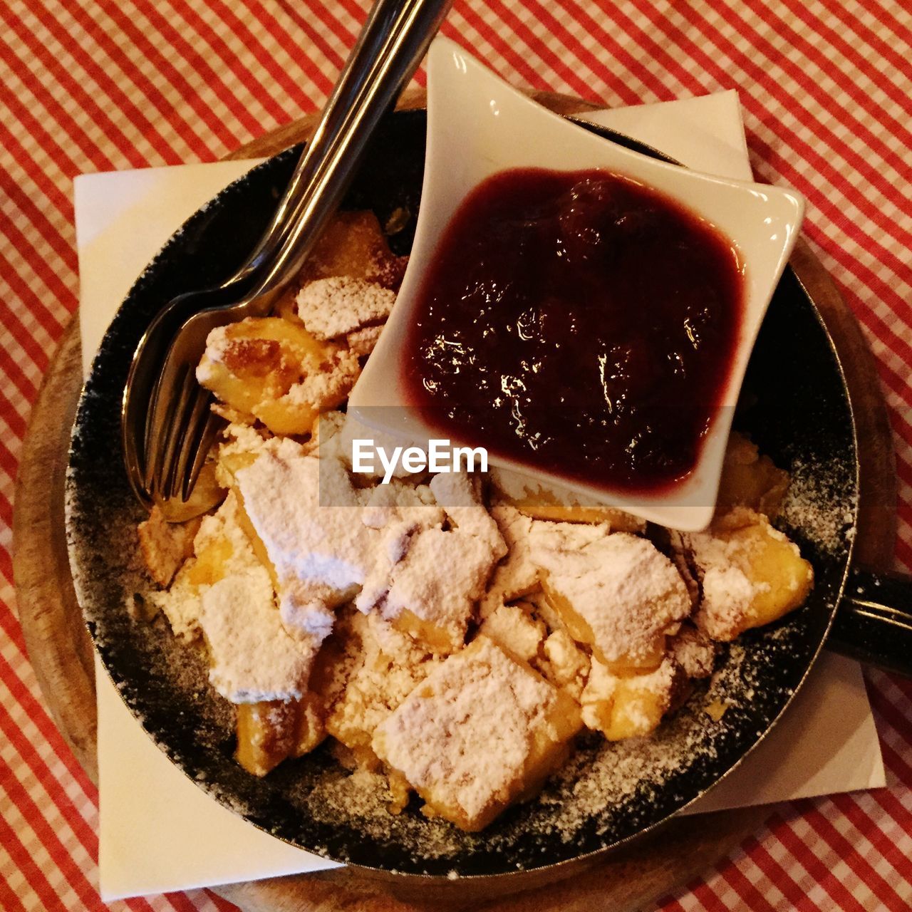 Directly above view of pancake in plate on checkered tablecloth