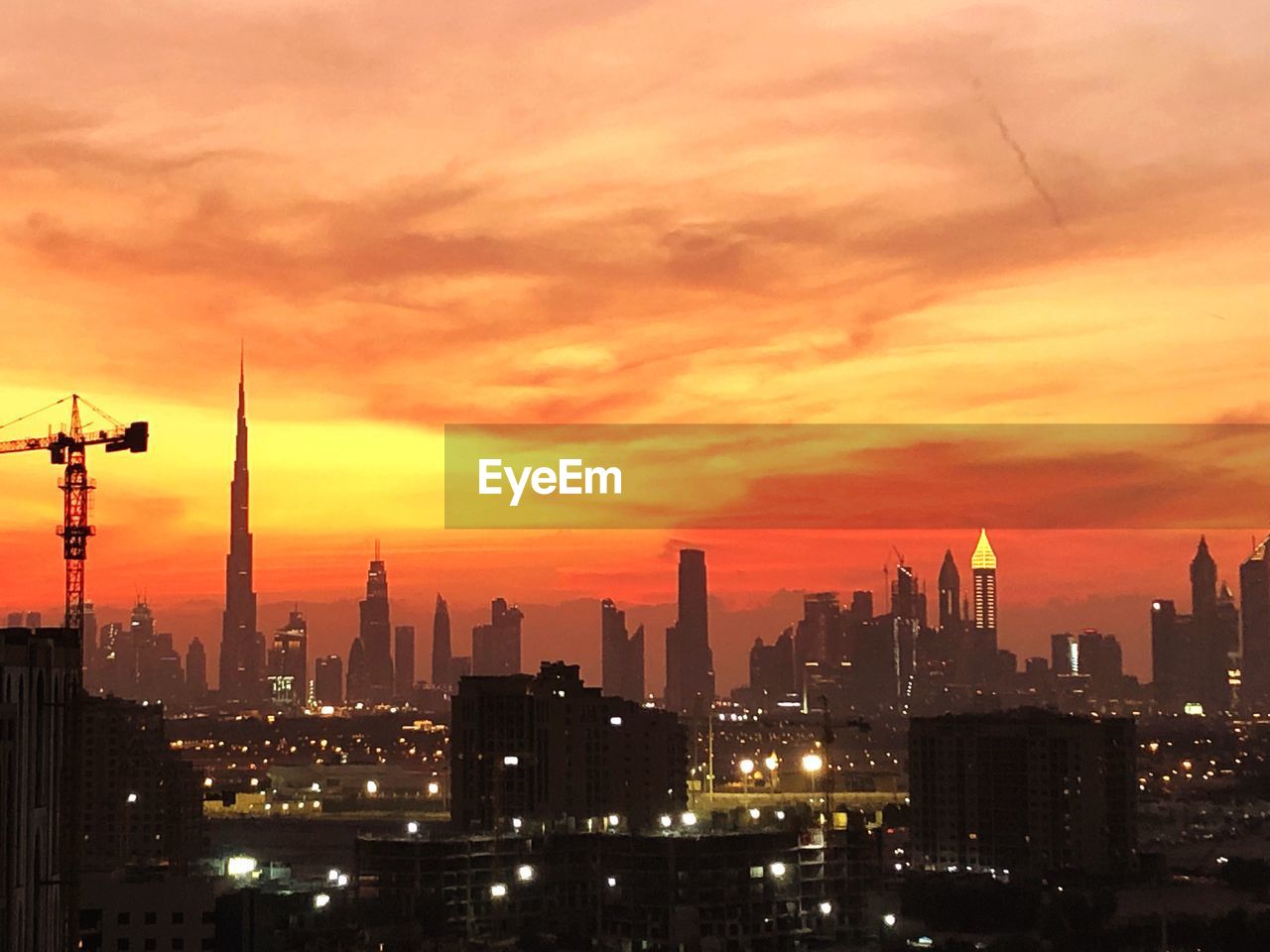 MODERN BUILDINGS IN CITY AGAINST ORANGE SKY