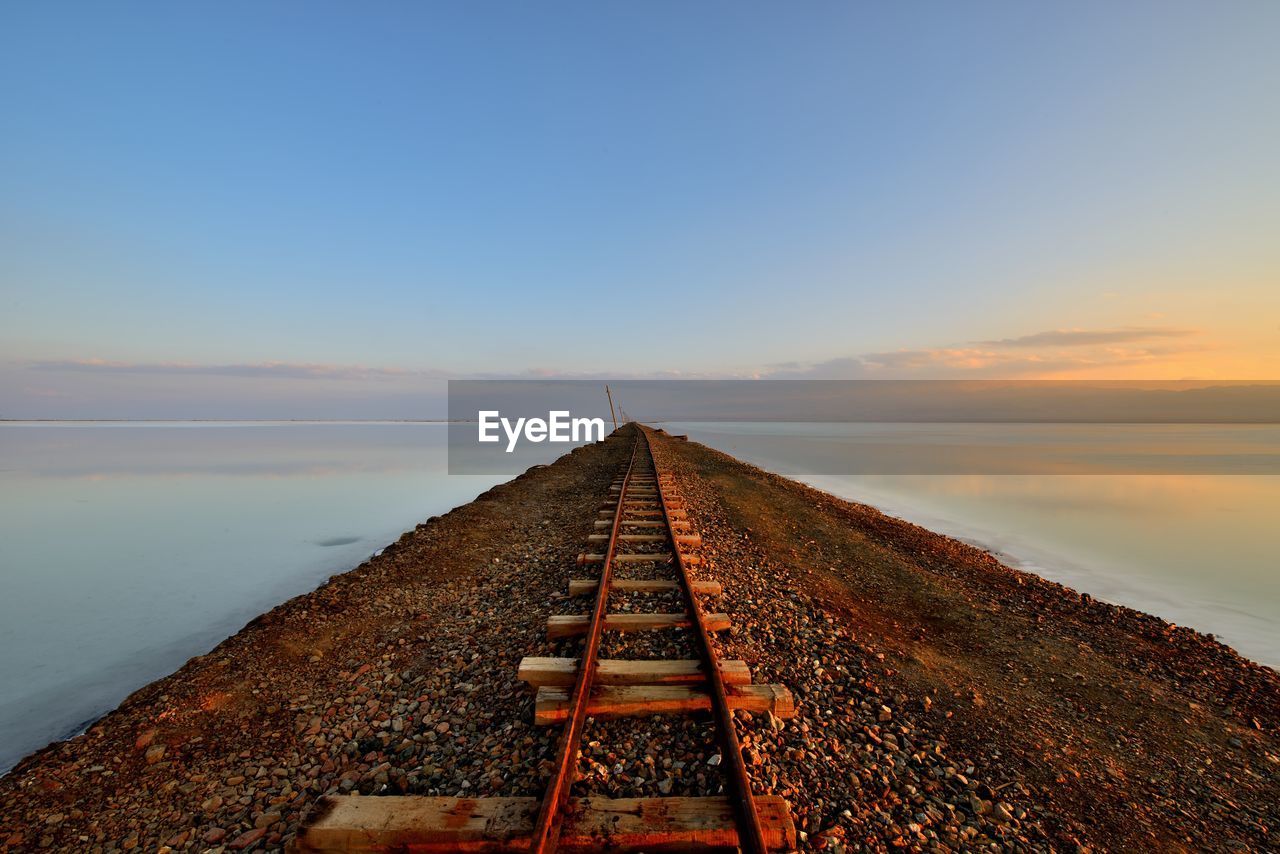 Scenic view of lake against clear sky during sunset