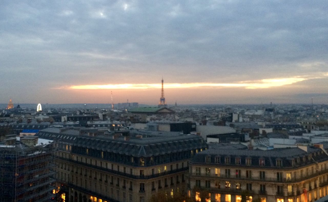 CITYSCAPE AGAINST CLOUDY SKY AT SUNSET