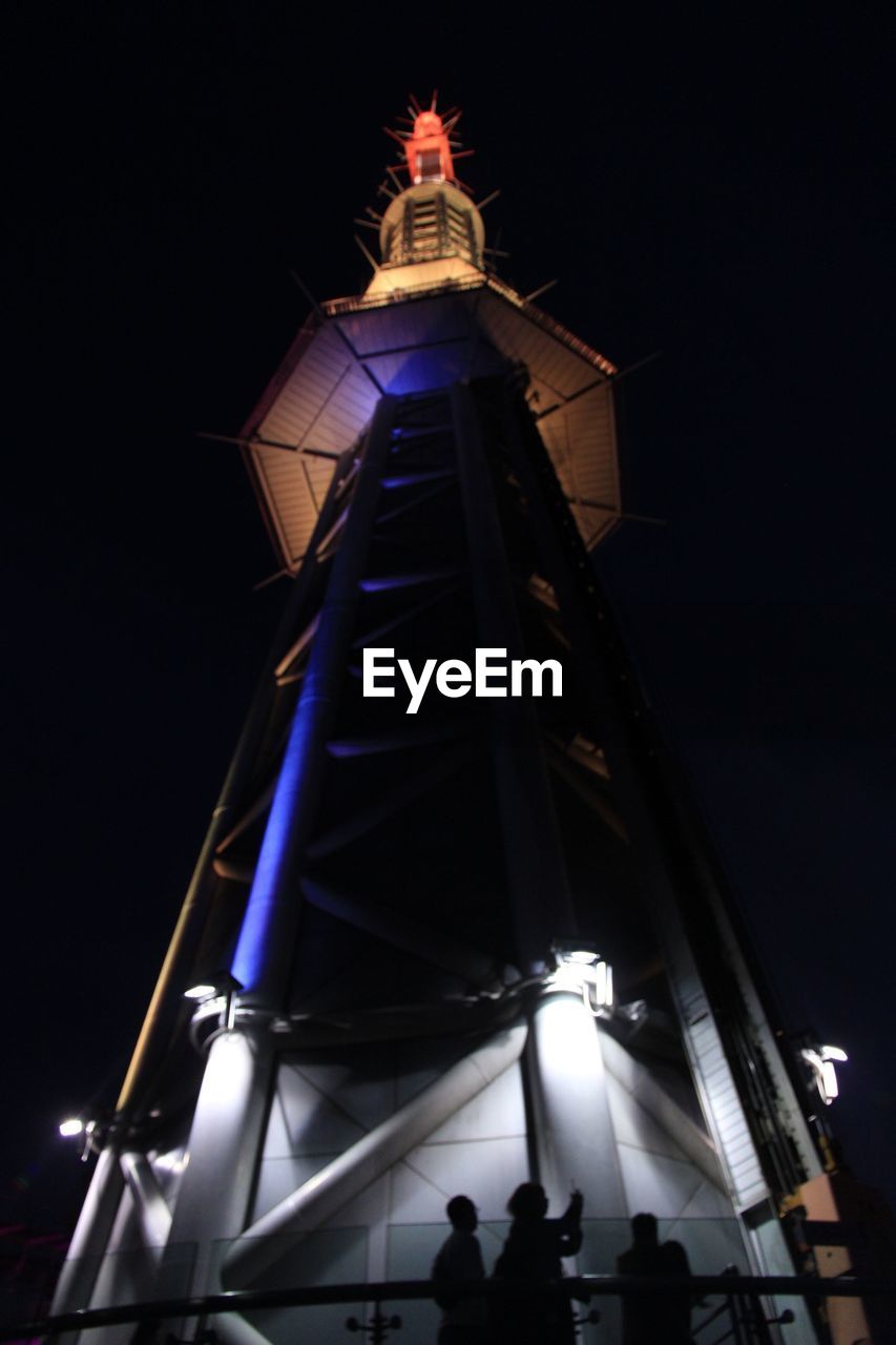 LOW ANGLE VIEW OF ILLUMINATED TOWER AT NIGHT