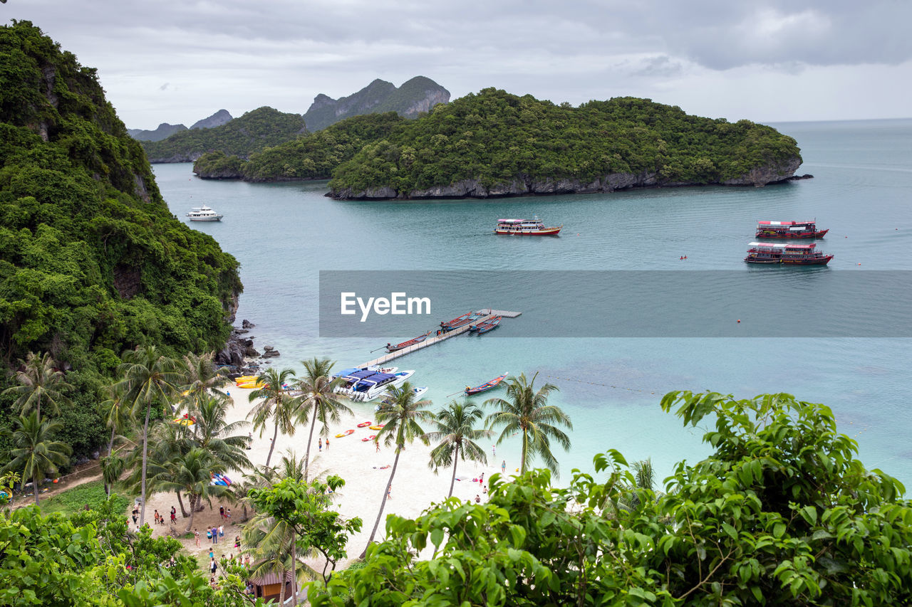 water, nautical vessel, sea, transportation, land, nature, beach, travel, beauty in nature, scenics - nature, mode of transportation, plant, sky, travel destinations, body of water, environment, tree, tourism, coast, cloud, vacation, holiday, trip, tranquility, coastline, ship, landscape, island, bay, shore, no people, bay of water, tranquil scene, cove, mountain, outdoors, idyllic, day, tropical climate, seascape, non-urban scene, high angle view, terrain, summer, forest, lagoon, architecture, vehicle, rock, cliff, social issues, watercraft, yacht, harbor, sailboat, moored