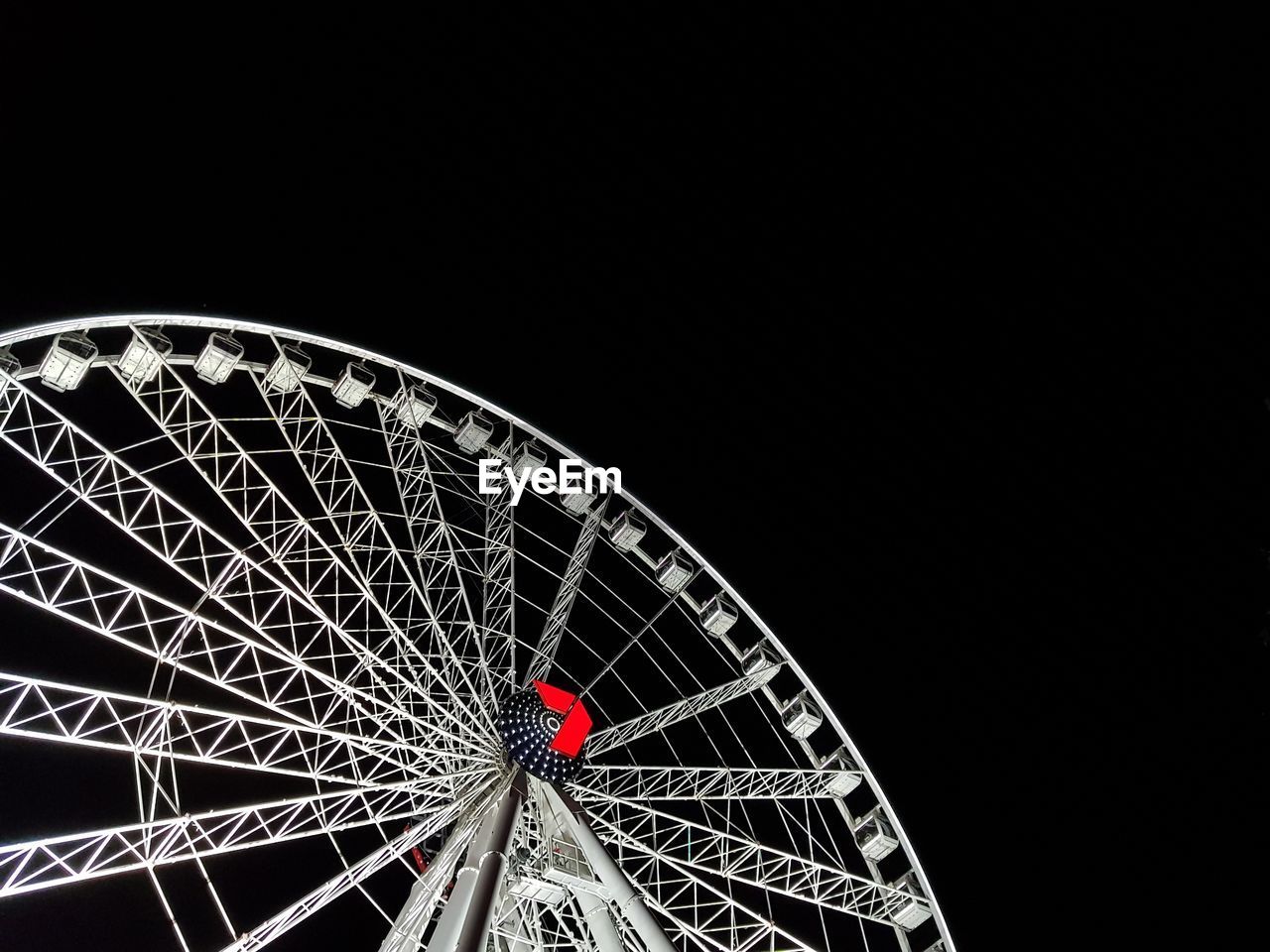 LOW ANGLE VIEW OF ILLUMINATED FERRIS WHEEL AGAINST SKY AT NIGHT