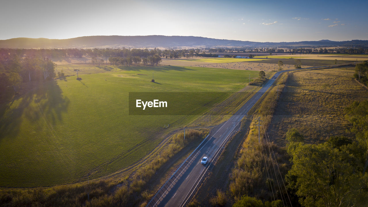 High angle view of road amidst field against sky