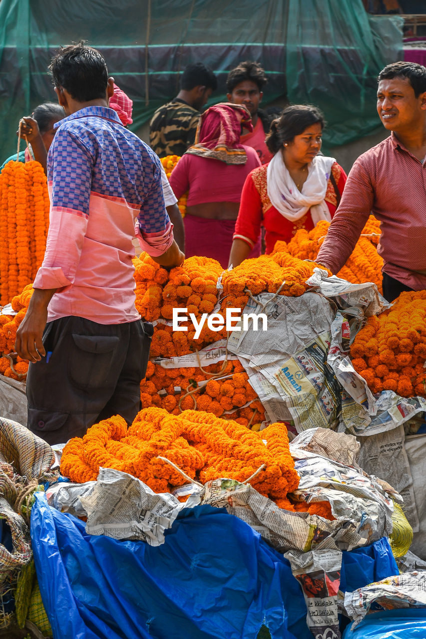 PEOPLE IN MARKET STALL