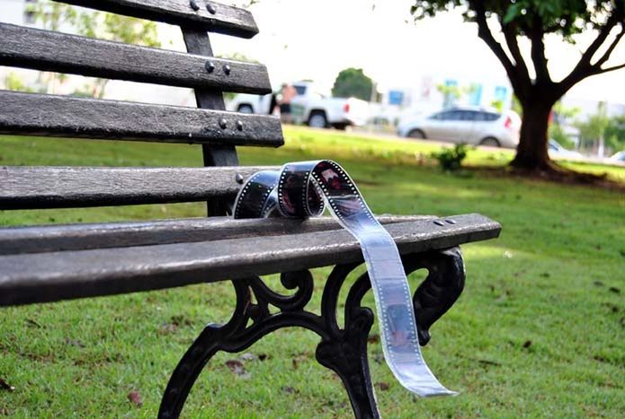 CLOSE-UP OF PARK BENCH ON GRASSY FOOTPATH