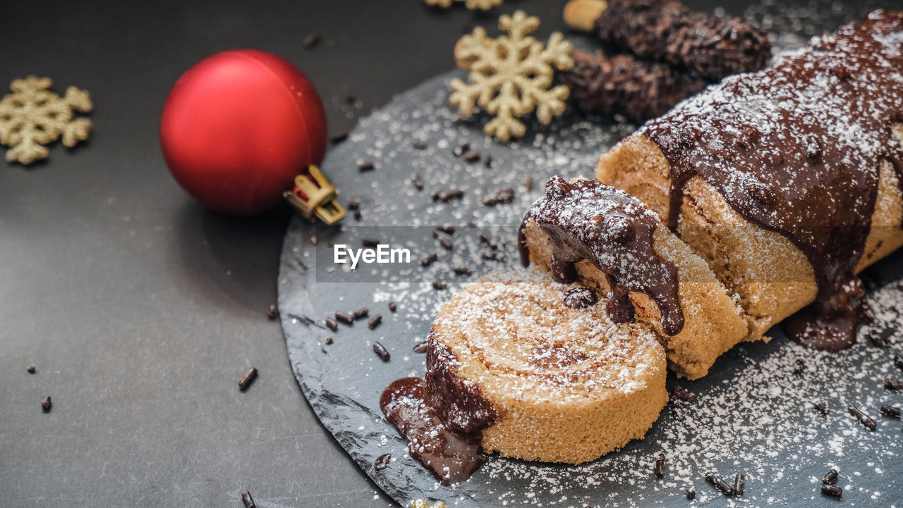 Christmas swiss roll cake top with chocolate fudge serve on the slate.