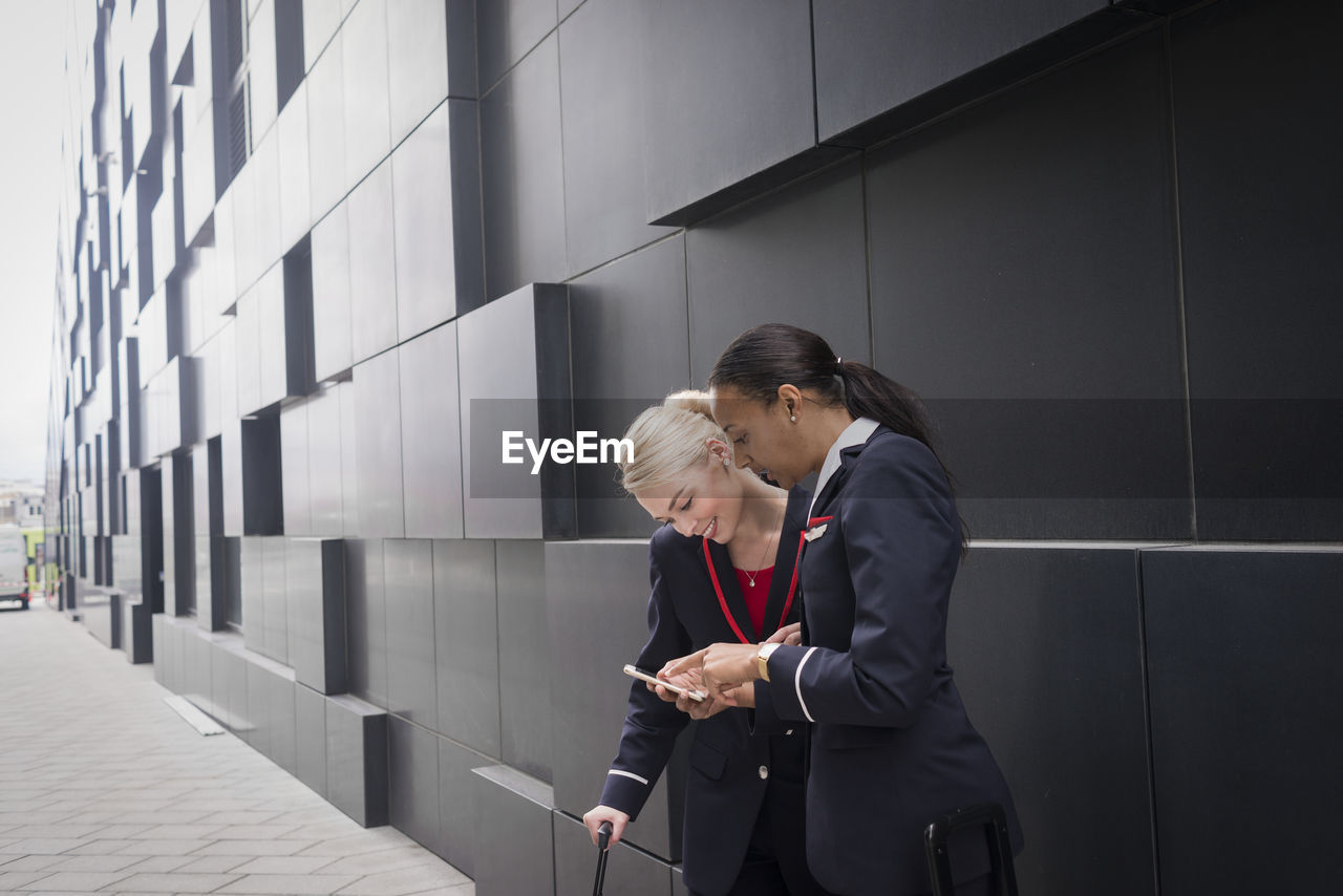 Two female flight attendants looking at cell phone