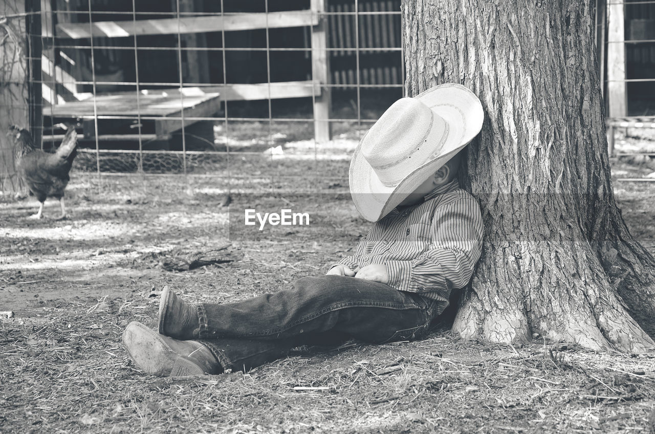 Man resting under tree in farm