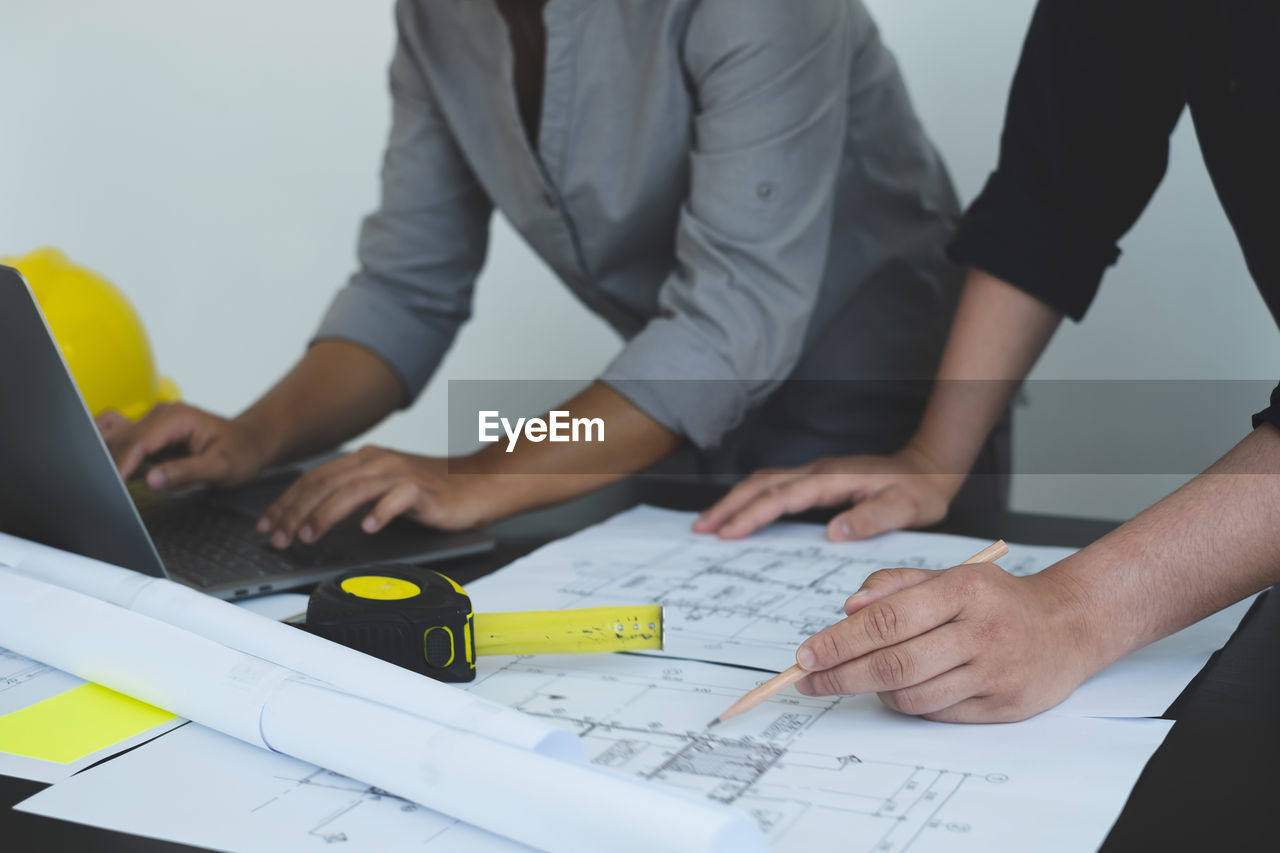 midsection of business colleagues working on table