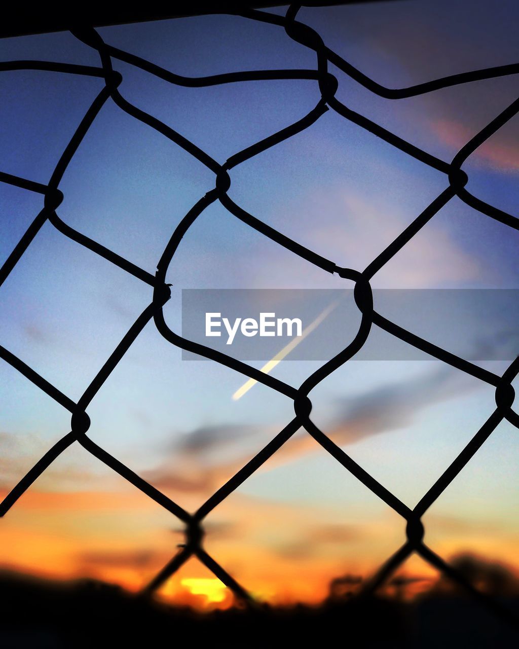 LOW ANGLE VIEW OF CHAINLINK FENCE AGAINST SKY