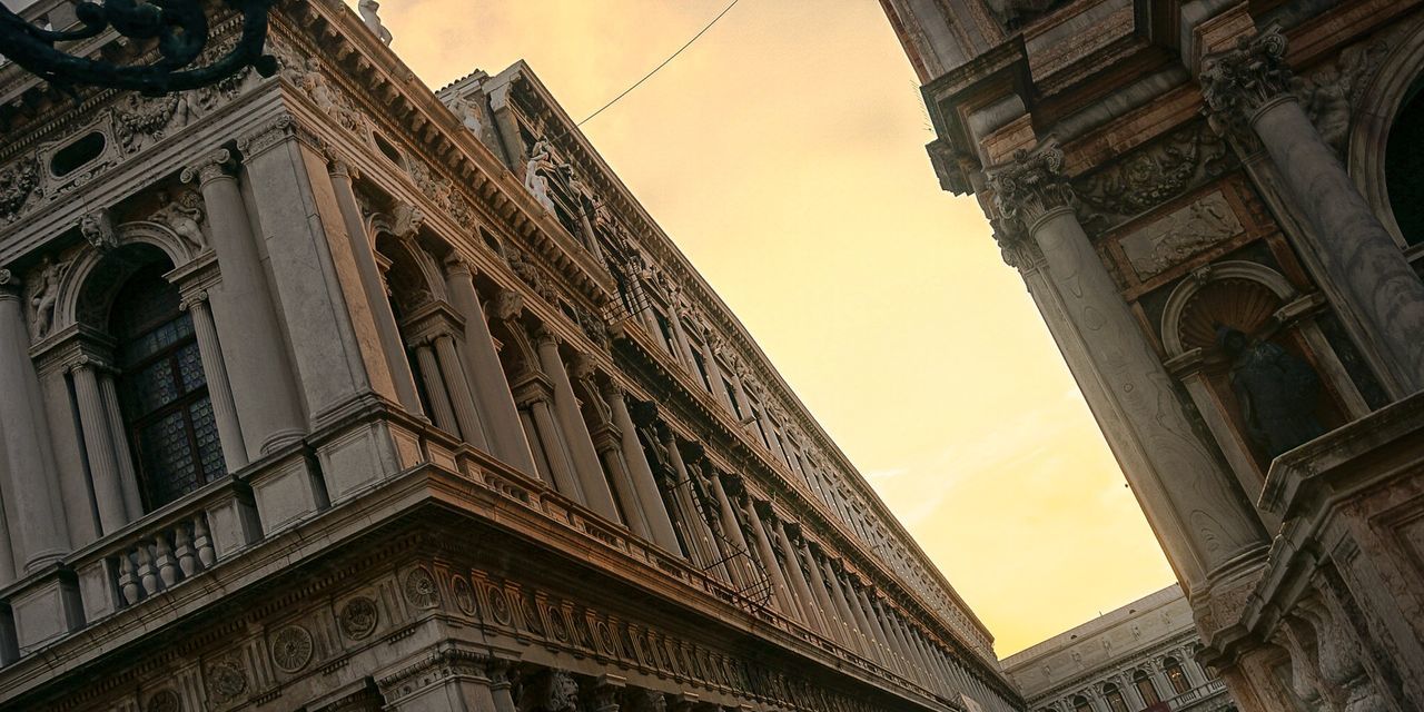 Low angle tilt image of historical buildings against sunset sky