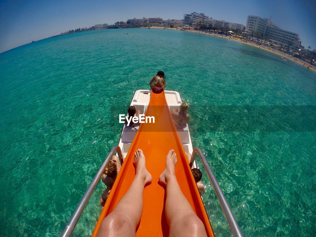 Low section of woman on slide in sea during sunny day