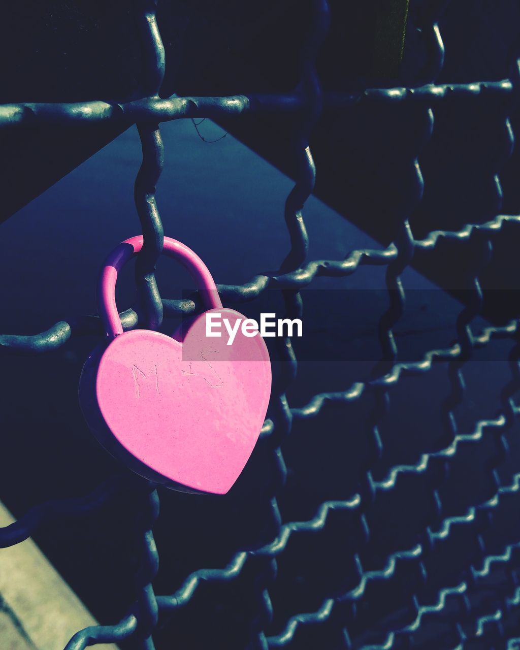 CLOSE-UP OF PADLOCKS ON HEART SHAPE HANGING