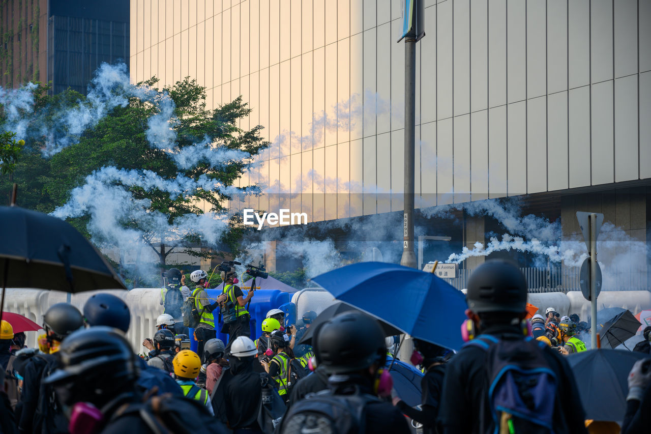 REAR VIEW OF PEOPLE ON STREET AGAINST BUILDING