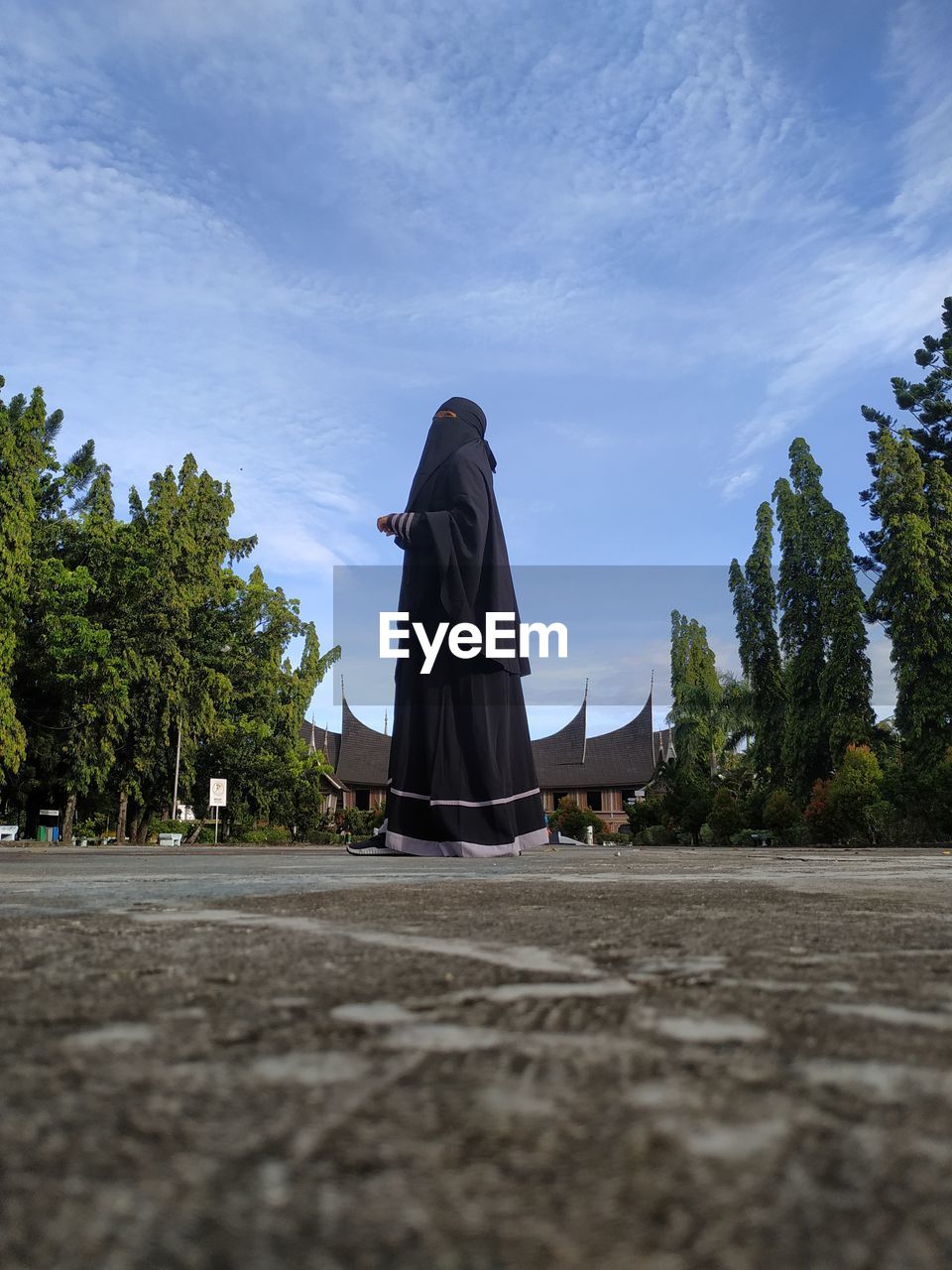 Rear view of woman walking on cross against sky