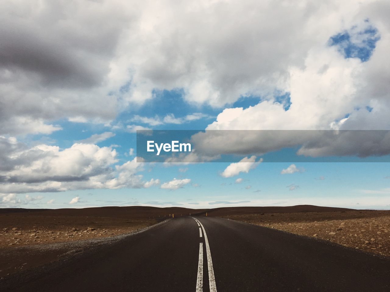 empty road against cloudy sky