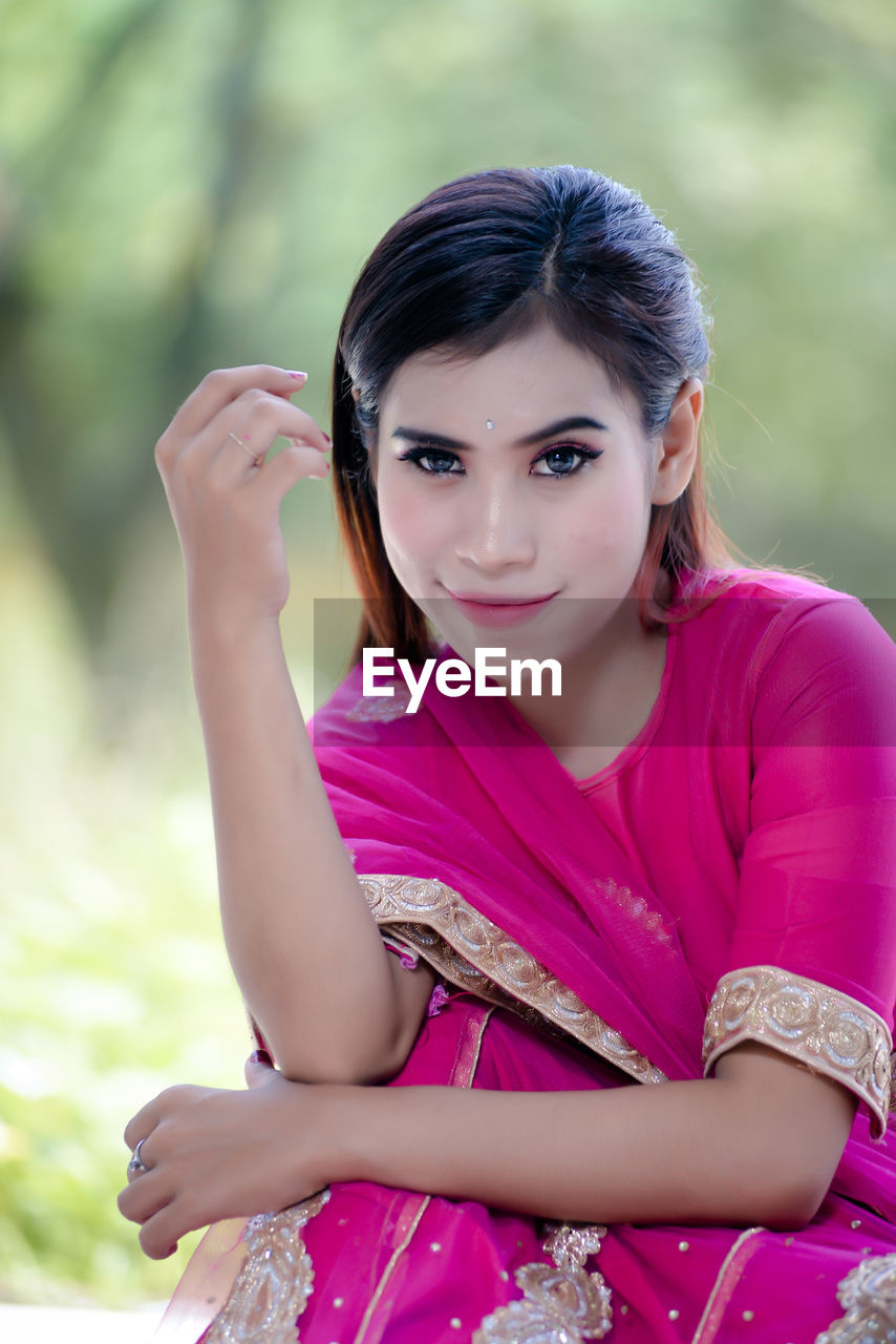 Portrait of young woman sitting on field