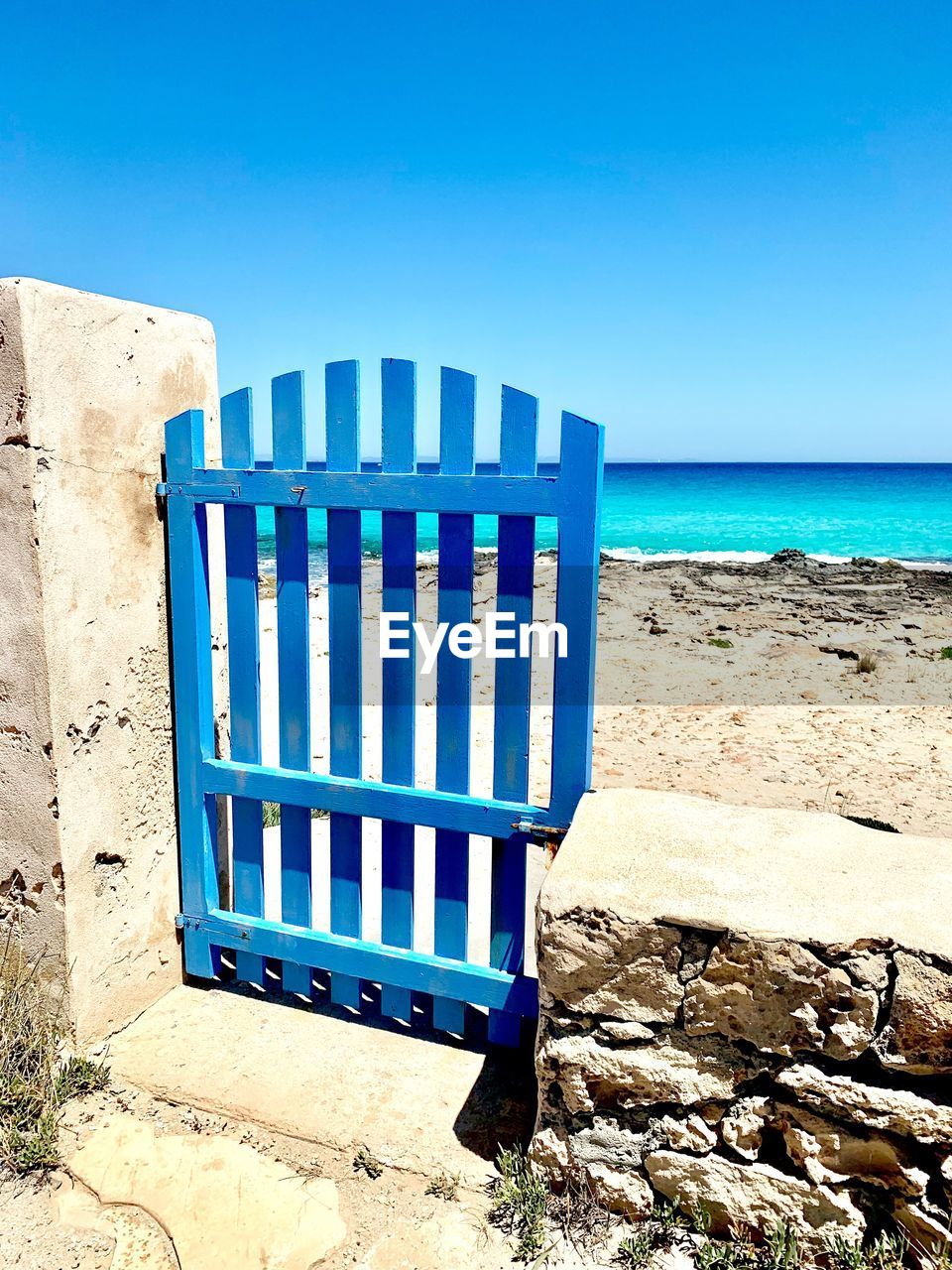 LIFEGUARD HUT ON BEACH AGAINST BLUE SKY