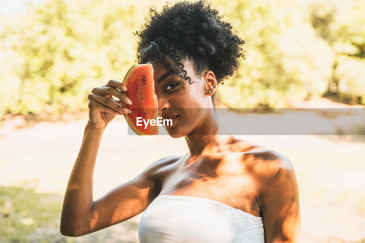 Portrait of young woman holding watermelon