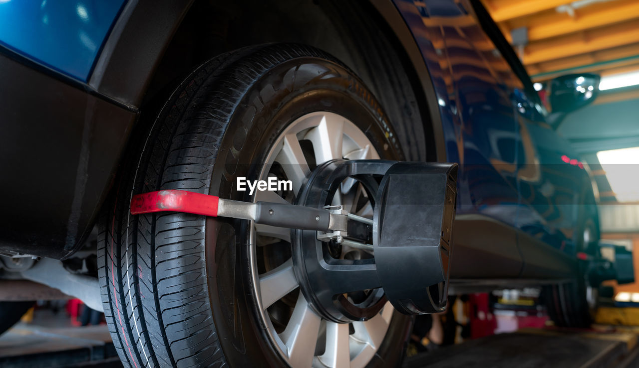 Wheel alignment equipment grip the tire of car wheel in car repair shop. auto wheel alignment 