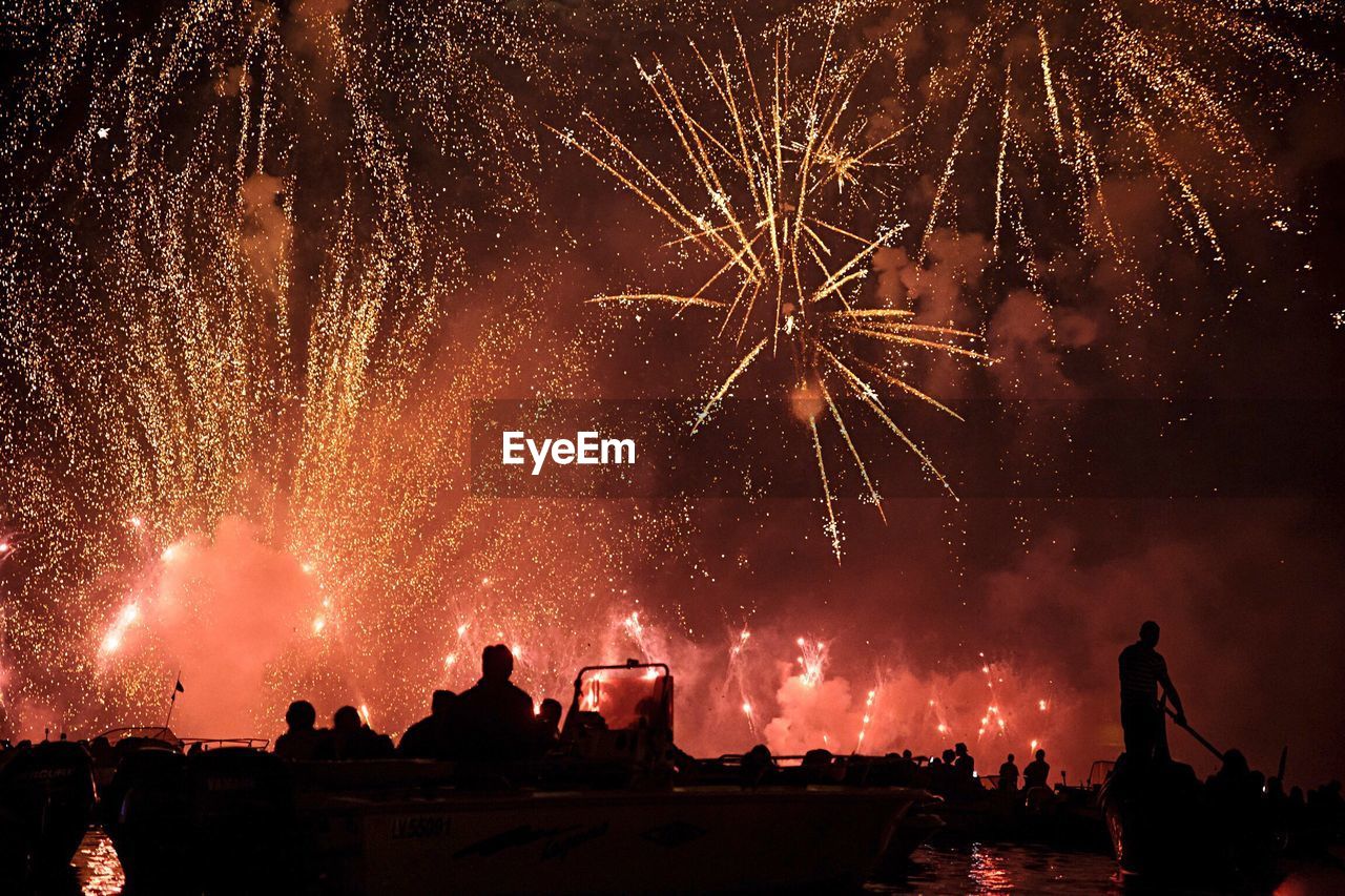 Low angle view of fireworks against sky at night