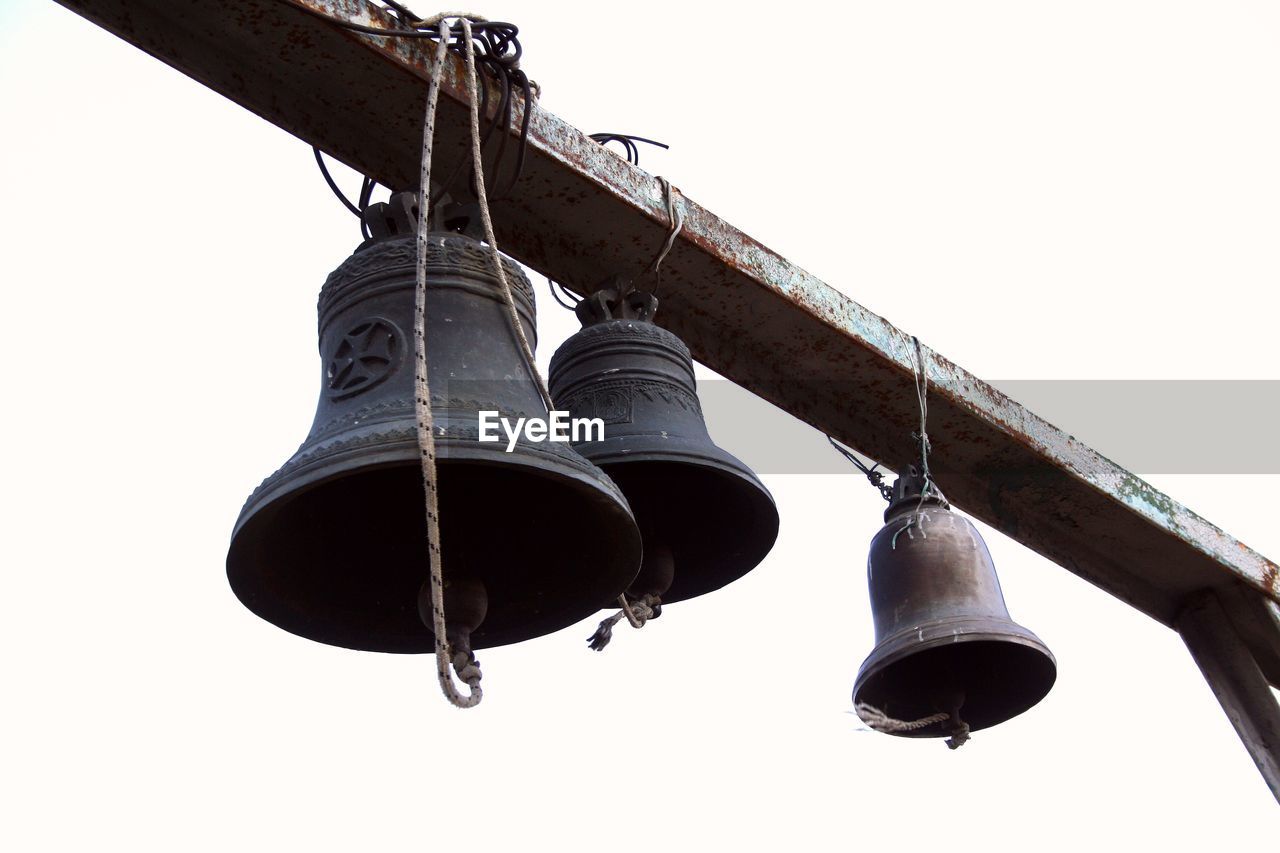 Low angle view of bell hanging against clear sky